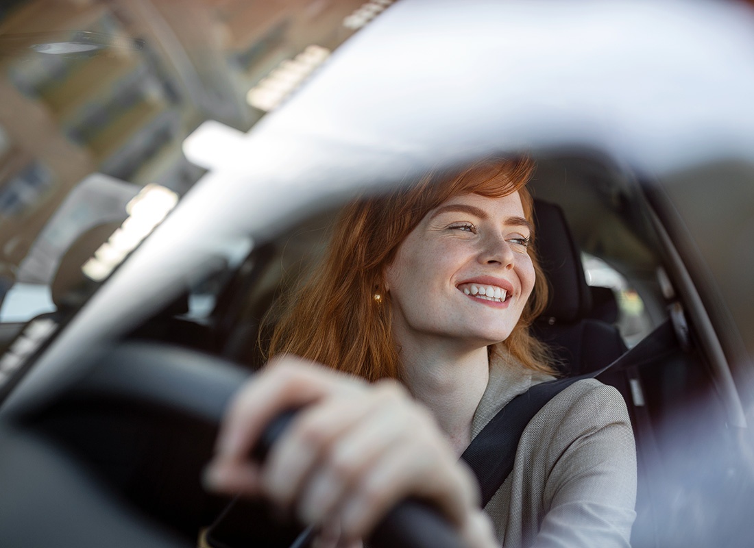 Contact - Portrait of a Cheerful Young Business Woman Driving her Car to Work in the City