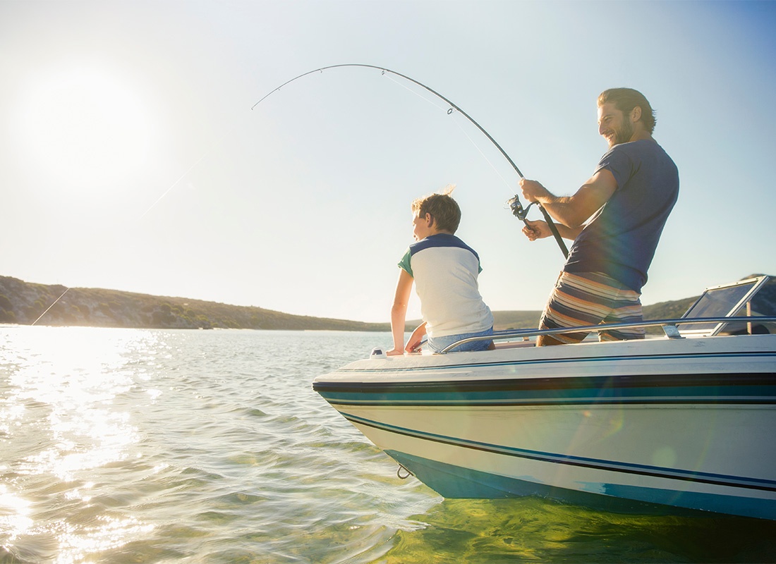 Insurance Solutions - View of a Father and Son Having Fun Fishing on a Boat Together During the Summer on a Lake